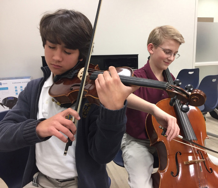 Photo by Vedha Batta
Bentonville scholars Jake Fennell, left, Jason Nuttle play the violin and cello during Fine Arts class.